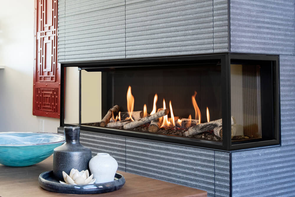Valor LX2 3-sided gas fireplace with birch logs and fluted black liner