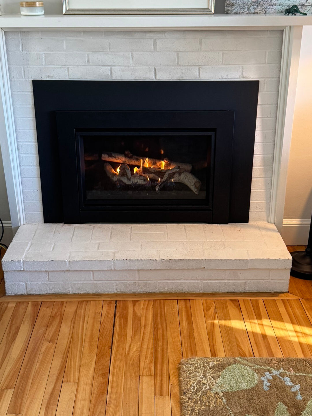 Gas fireplace insert installed by Hearth Doctor in a white brick fireplace
