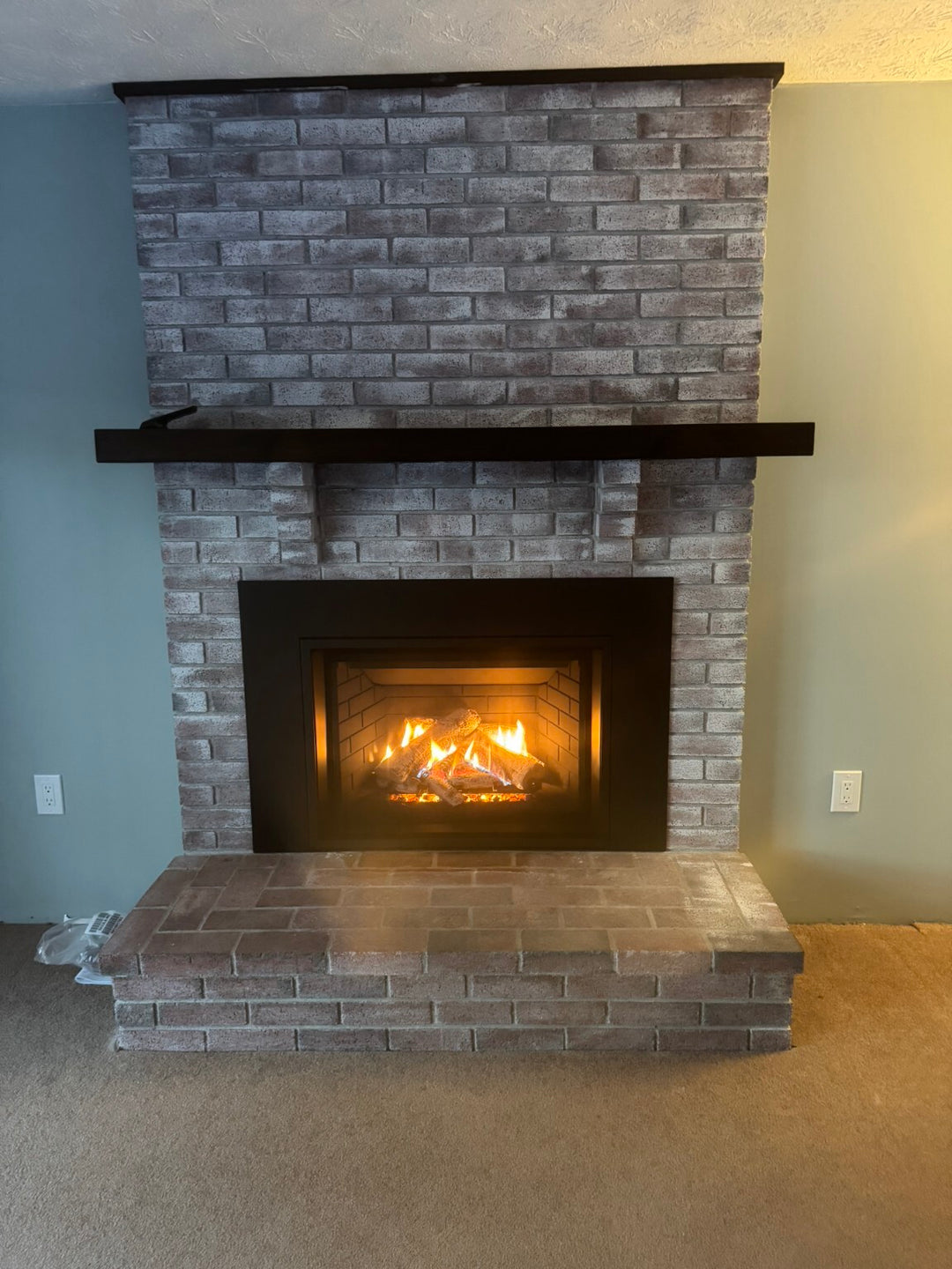 Finished built-in gas fireplace installed by Hearth Doctor in a brick feature wall